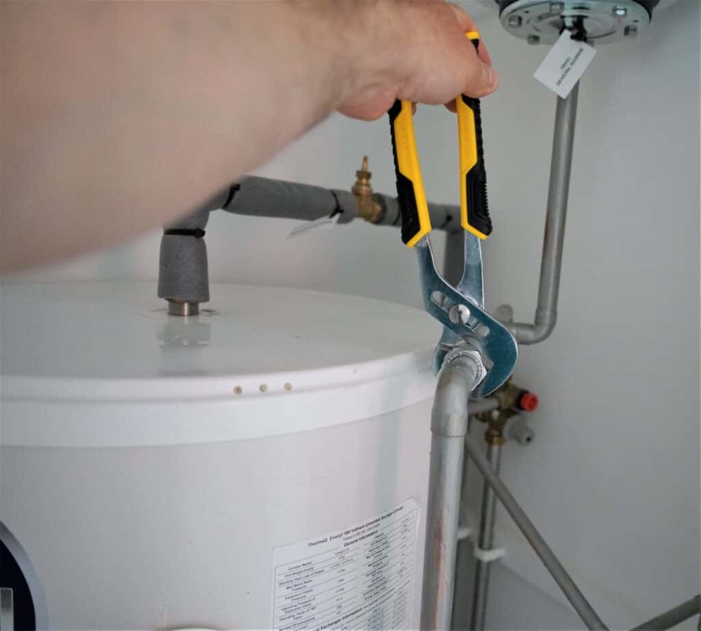 Photo of water heater and person working on piipes