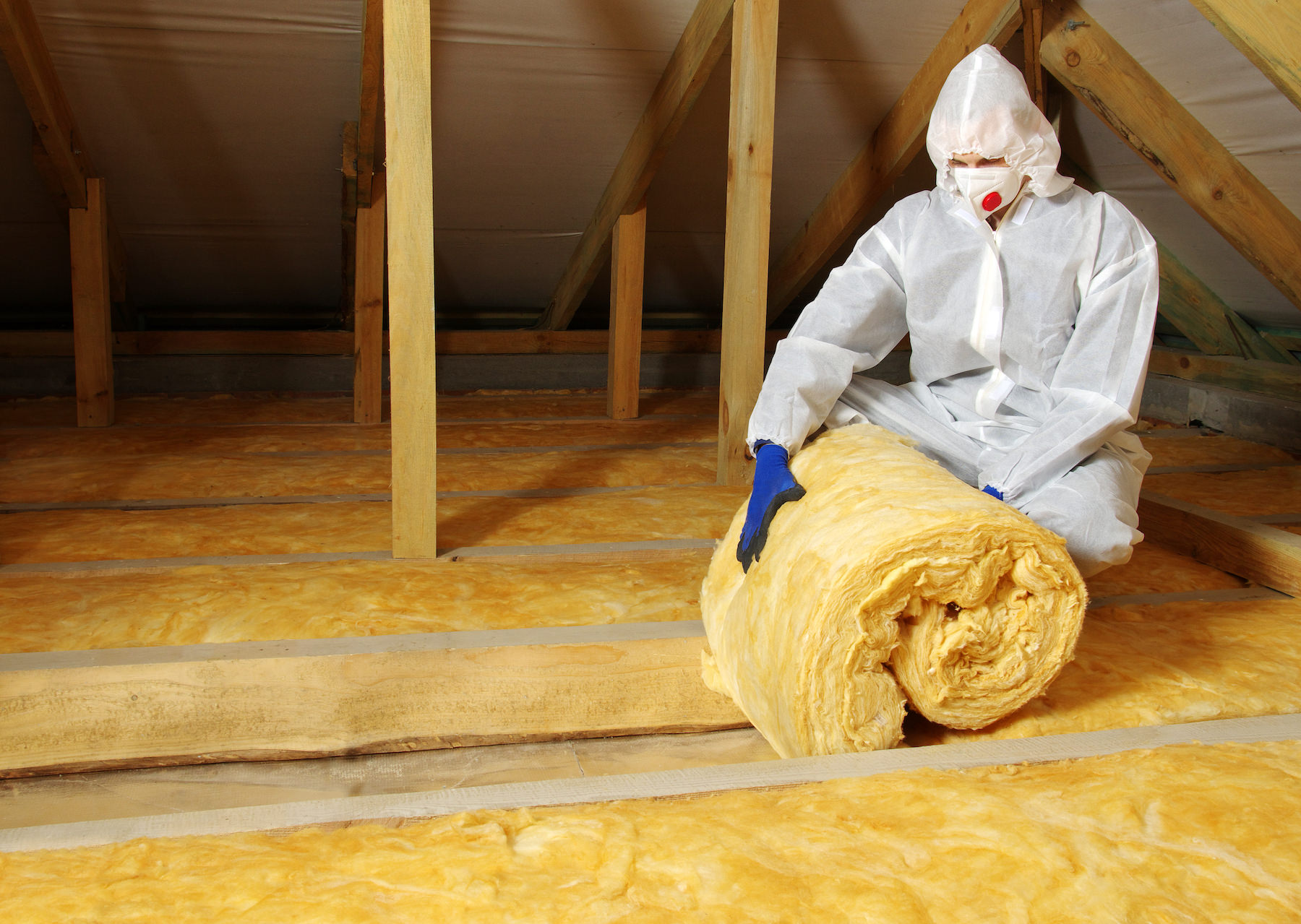 Construction Worker Thermally Insulating House Attic With Glass Wool